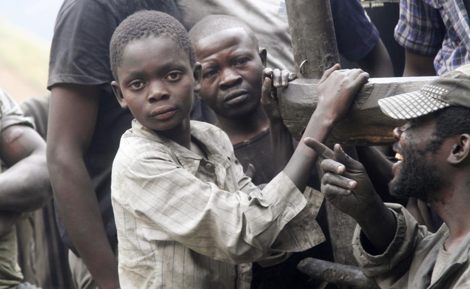 Boys working as artisanal miners take a break from panning for gold at the Marco gold mine in Mukungwe locality in Walungu territory of South Kivu May 9, 2014. Decades of corruption, mismanagement and violence have blighted the development of Congo, which at the time of independence in 1960 was Africa's second most industrialised economy. In 2013 it was near the foot of global tables for per capita economic output. Now industrial mining operations are moving back to regions that have been the preserve of artisanal miners since the collapse of Congo's state-run mining operations in the 1990s, at the end of dictator Mobutu Sese Seko's 31-year rule. Picture taken May 9, 2014. REUTERS/Kenny Katombe (DEMOCRATIC REPUBLIC OF CONGO - Tags: BUSINESS EMPLOYMENT INDUSTRIAL COMMODITIES CIVIL UNREST POLITICS)