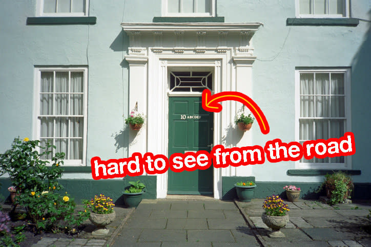 a house with an arrow pointing to the number on the door and the words "hard to see from the road"