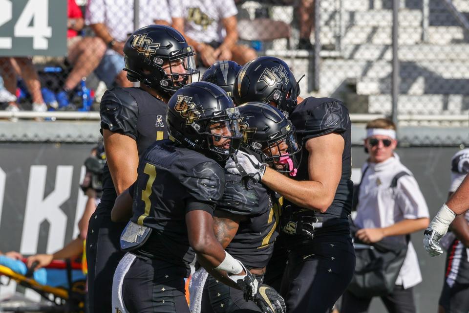 Oct 29, 2022; Orlando, Florida, USA; UCF Knights running back RJ Harvey (22) celebrates with teammates after scoring during the first quarter against the Cincinnati Bearcats at FBC Mortgage Stadium. Mandatory Credit: Mike Watters-USA TODAY Sports