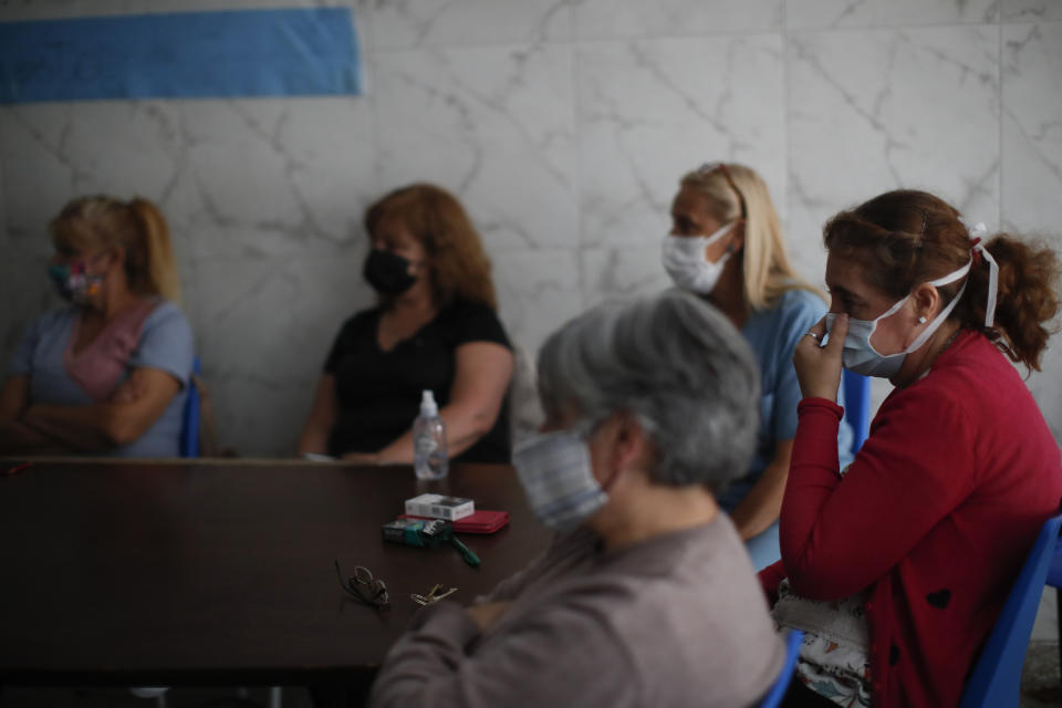 Former workers sit inside San Andres Clinic which they have been occupying since it closed at the start of the year following the death of the hospital's director and owner in Caseros, Argentina, Friday, April 30, 2021. While the pandemic has swelled the need for hospital beds, many private clinics say they're struggling to survive, citing the pandemic having pushed away many non-COVID patients and losing money on coronavirus sufferers because the government insurance program doesn't pay enough to meet costs. (AP Photo/Natacha Pisarenko)