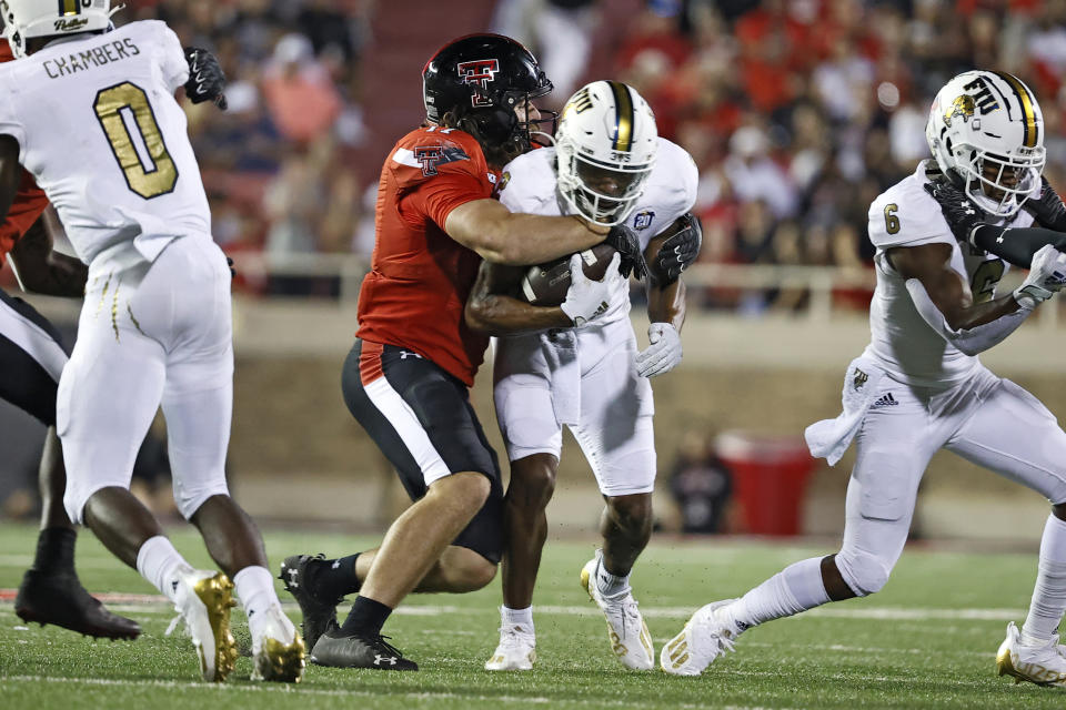 Texas Tech's Colin Schooler, center left, tackles Florida International's Bryce Singleton, center right, during the second half of an NCAA college football game on Saturday, Sept. 18, 2021, in Lubbock, Texas. (AP Photo/Brad Tollefson)