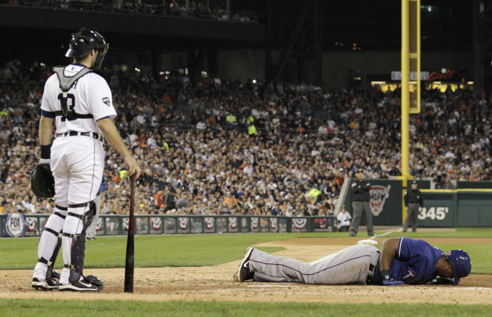 Texas Rangers' Adrian Beltre falls over in front of Detroit Tigers catcher Alex Avila after fouling a ball off his leg during the fourth inning of Game 3 of baseball's American League championship series against the Detroit Tigers, Tuesday, Oct. 11, 2011, in Detroit. (AP Photo/Charlie Riedel)