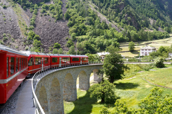 Swiss mountain train Bernina Express  passes the spiral of the Brusio Viaduct