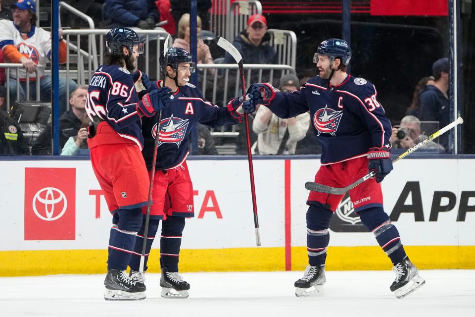 Mar 24, 2023; Columbus, Ohio, USA;  Columbus Blue Jackets right wing Kirill Marchenko (86) and center Boone Jenner (38) celebrate a goal by left wing Johnny Gaudreau (13) during the second period of the NHL hockey game against the New York Islanders at Nationwide Arena. Mandatory Credit: Adam Cairns-The Columbus Dispatch