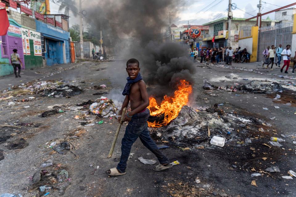 A man walks past a burning barricade during a protest against Haitian Prime Minister Ariel Henry calling for his resignation in Port-au-Prince, Haiti, Oct. 10, 2022. Haitian Prime Minister Ariel Henry has agreed to resign and make way for a transitional authority, the president of Guyana and a U.S. official said Monday after a regional meeting on a gang uprising that has plunged Haiti into violent chaos. Henry, an unelected leader who took power right before Haiti's president was assassinated in 2021, was under acute pressure from parties, including the United States, to yield to some new power arrangement as the already poor and unstable country fell further into bedlam.