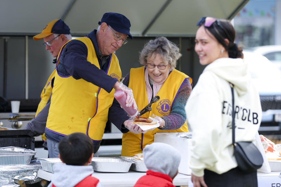 Neil, second left, and Marilyn of the Lions Club of Wainuiomata, work at a barbecue stall during Matariki Whanau Day at the Wainuiomata Community Hub in Wellington, New Zealand on June 22, 2024. Now in its third year as a nationwide public holiday in New Zealand, Matariki marks the lunar new year by the rise of the star cluster known in the Northern Hemisphere as the Pleiades. (AP Photo/Hagen Hopkins)