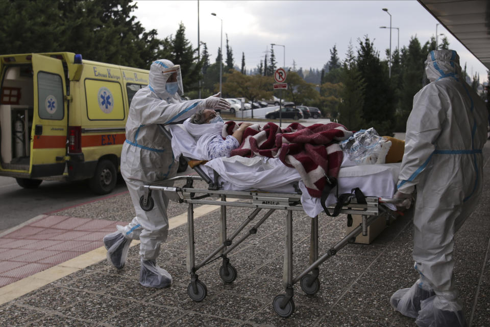 Medical personnel transfer a COVID-19 patient from a state to a private clinic which has been appropriated, in the northern city of Thessaloniki, Greece, Sunday, Nov. 29, 2020. Greece's Health ministry has forcibly appropriated two clinics and their staff in the country's second populated city, where the outbreak is the most severe. (AP Photo/Achilleas Chiras)