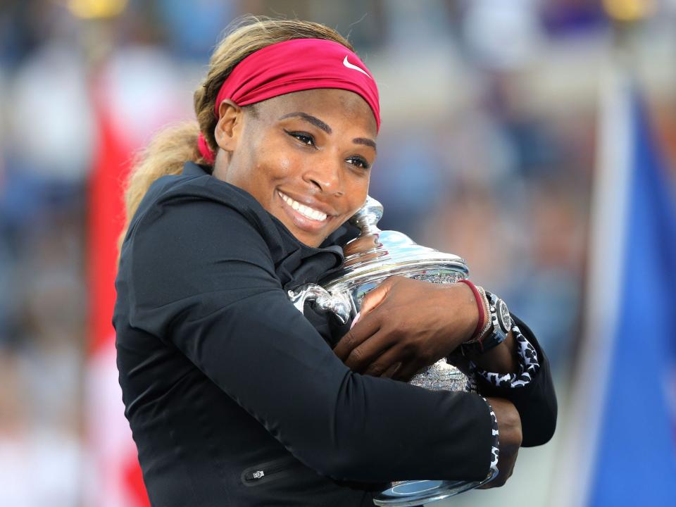 Serena Williams hugs her 2014 US Open trophy.