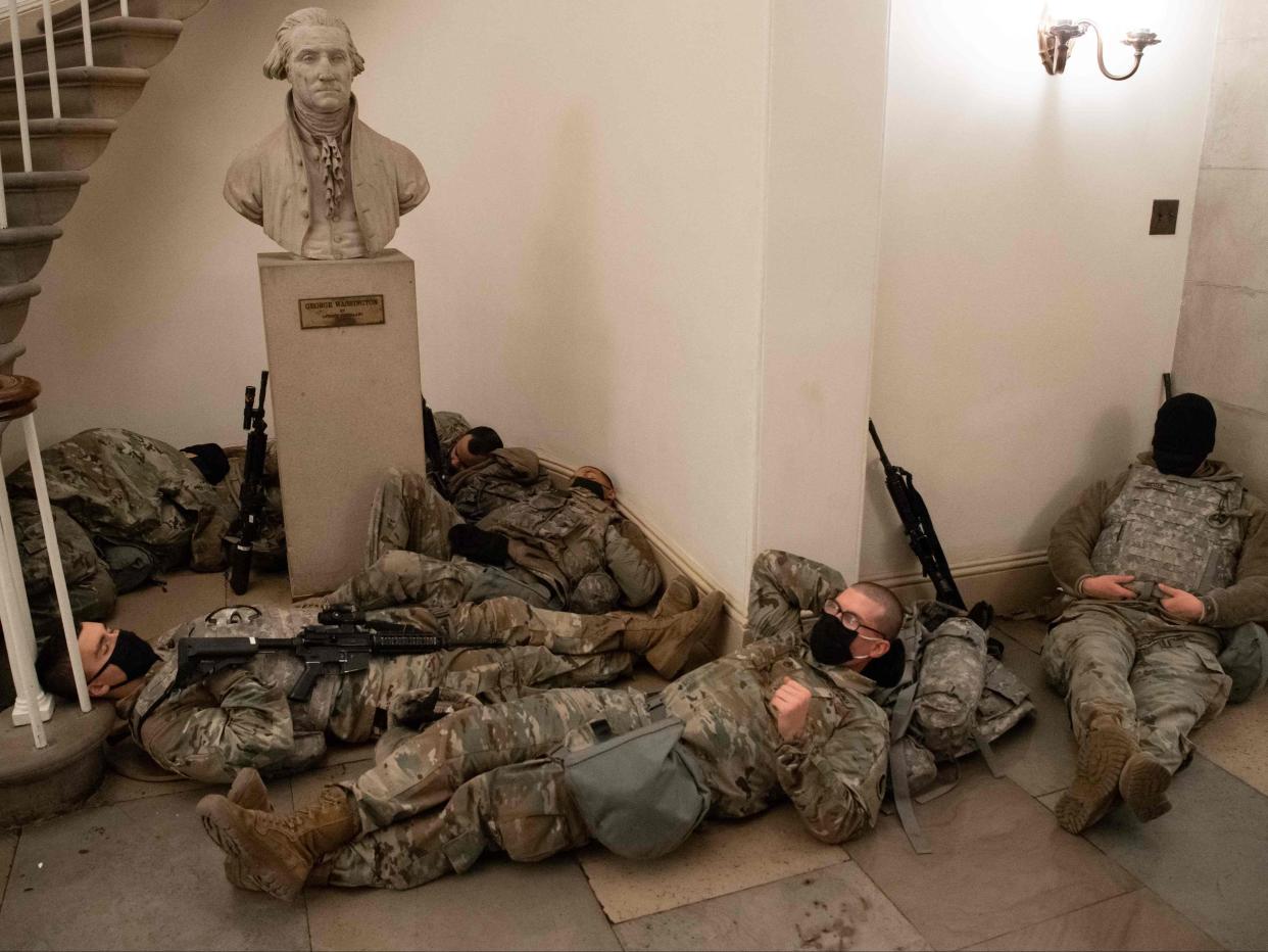 <p>Members of the National Guard take a rest in the Rotunda of the US Capitol in Washington, DC on 13 January 2021</p> ((AFP via Getty Images))