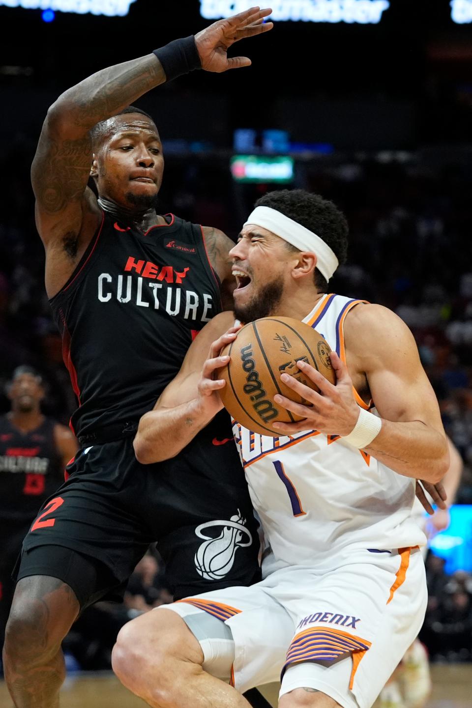 Phoenix Suns guard Devin Booker (1) goes up for a shot against Miami Heat guard Terry Rozier III during the first half of an NBA basketball game, Monday, Jan. 29, 2024, in Miami
