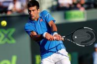 Novak Djokovic hits a backhand against Steve Darcis (not pictured) on day eight of the Miami Open at Crandon Park Tennis Center. Djokovic won 6-0, 7-5. Mandatory Credit: Geoff Burke-USA TODAY Sports