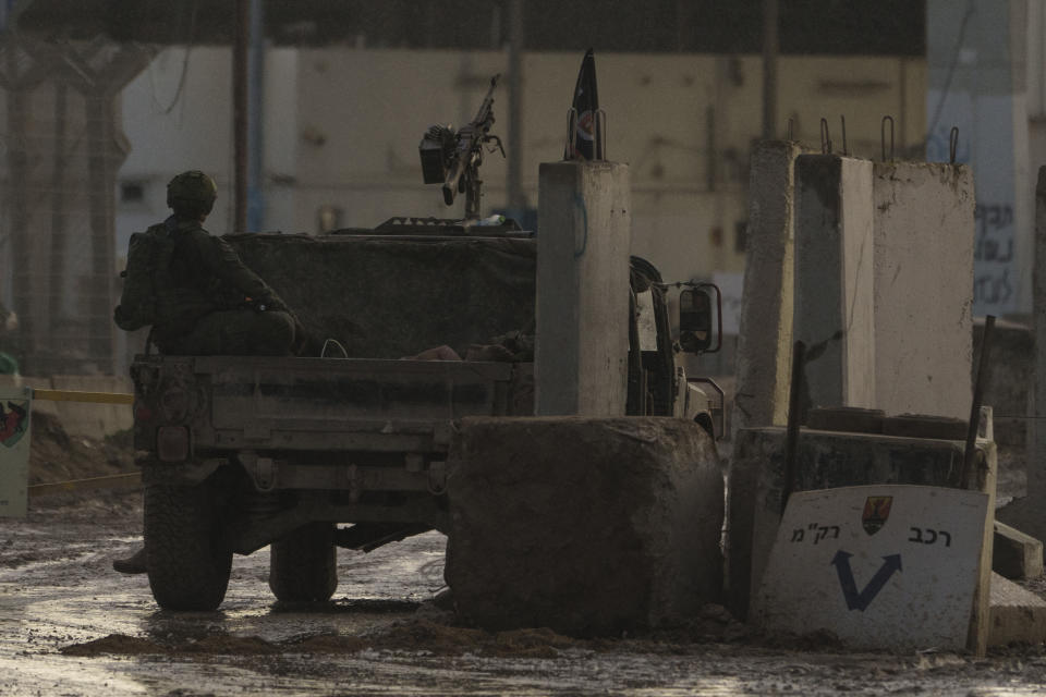 A person is seen detained on the back of an Israeli army vehicle in Erez crossing at the Israeli-Gaza border, southern Israel, Tuesday, Jan. 2, 2024. (AP Photo/Leo Correa)