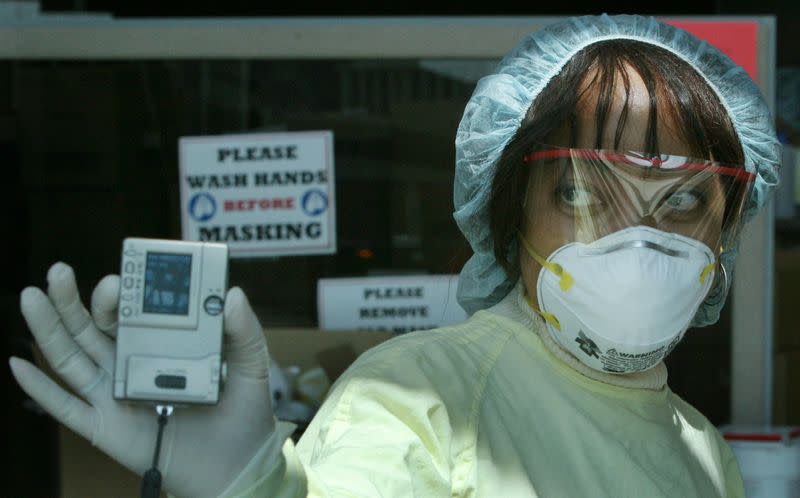 FILE PHOTO: NURSE WEARING MASK SHOWS PHOTO TO MEDIA.