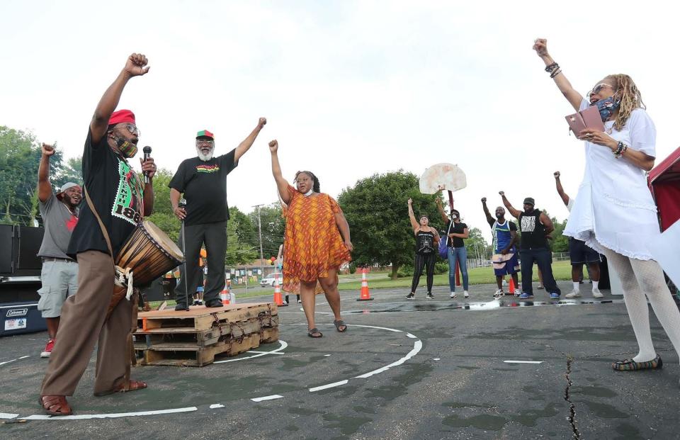 Kwame Williams, left, with a djembe, a West African drum, leads the "Minute by Minute," a motivational call-and -esponse technique used in traditional African music, during the 2020 Juneteenth celebration at Stoner/Hawkins Park in Akron.