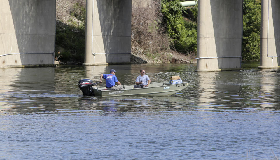 In this Thursday, Aug. 15, 2019, photo officials from IDEM check the waters near Portage Marina after several dead fish had been spotted floating in the waterway in Portage, Ind. Some beaches along northwestern Indiana's Lake Michigan shoreline are closed after authorities say a chemical spill in a tributary caused a fish kill. (John Luke/The Times via AP)