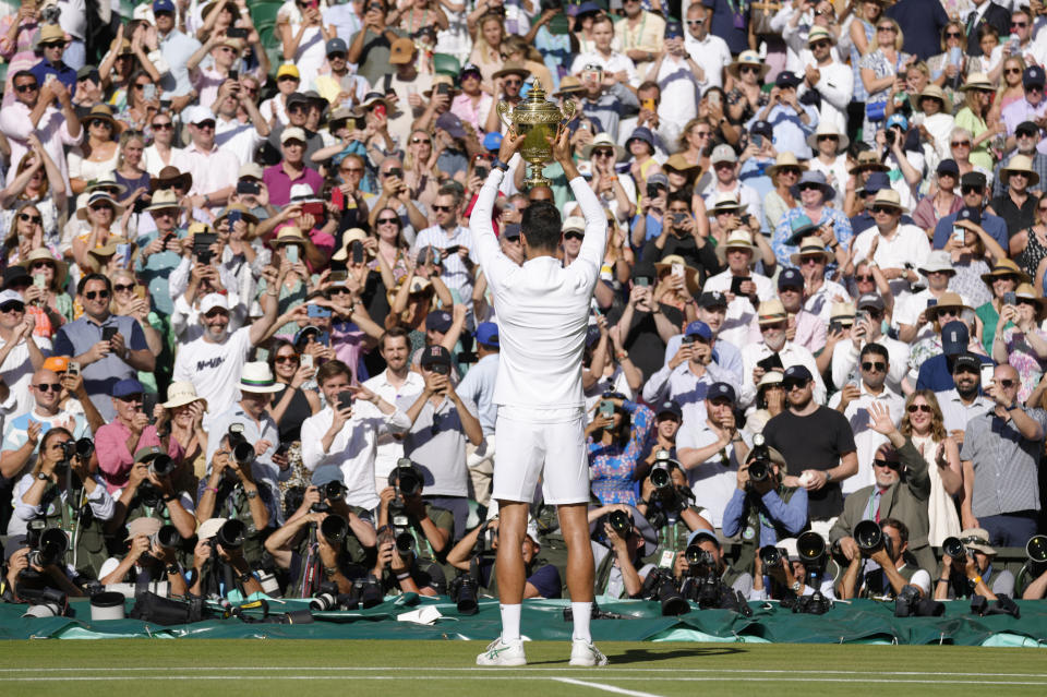 Serbia's Novak Djokovic celebrates with the trophy after beating Australia's Nick Kyrgios in the final of the men's singles on day fourteen of the Wimbledon tennis championships in London, Sunday, July 10, 2022. (AP Photo/Kirsty Wigglesworth)