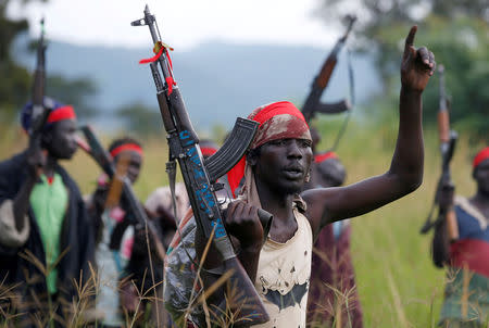 FILE PHOTO: SPLA-IO (SPLA-In Opposition) rebels hold up guns in Yondu, the day before an assault on government SPLA (Sudan People's Liberation Army) soldiers in the town of Kaya, on the border with Uganda, South Sudan, August 25, 2017. REUTERS/Siegfried Modola/File Photo