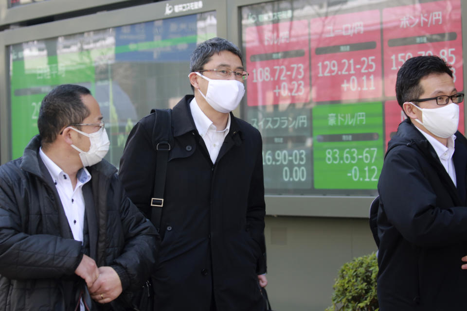 People walk by an electronic stock board of a securities firm in Tokyo, Wednesday, March 10, 2021. Shares are higher in Asia after gains for major tech companies powered a 3.7% surge in the Nasdaq, the largest jump for the index in four months. (AP Photo/Koji Sasahara)