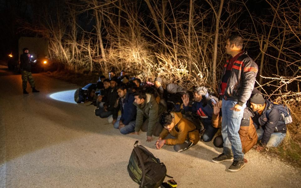 Greek Army soldiers detain a group of migrants after they crossed from Turkey to Greece in the Evros region of northern Greece - Reuters