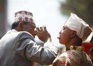 A man checks the tongue of Jujubhai Bans Shrestha (R) after it was pierced with an iron spike during the Tongue Penetration Festival at Bode near Kathmandu April 14, 2012. It is believed that after a volunteer from a Shrestha family successfully gets his tongue pierced in a spiritual trance with an iron spike and walks around the town shouldering a round bamboo rack with a flaming torch, it brings good fortune to the villagers. REUTERS/Navesh Chitrakar