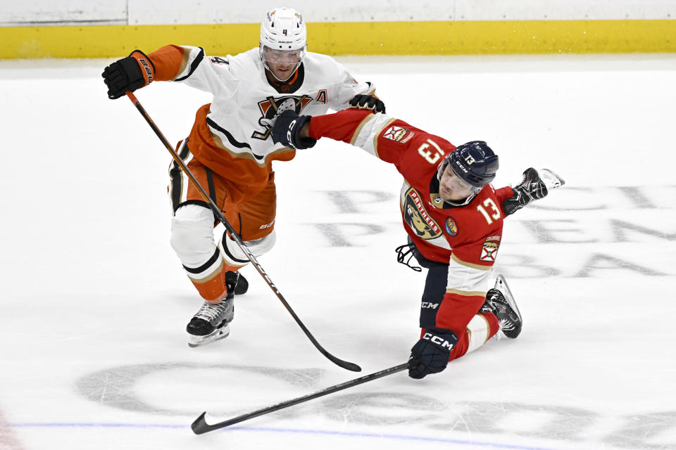 Anaheim Ducks defenseman Cam Fowler, left, trips up Florida Panthers center Sam Reinhart to draw a penalty during the third period of an NHL hockey game in Anaheim, Calif., Sunday, Nov. 6, 2022. (AP Photo/Alex Gallardo)