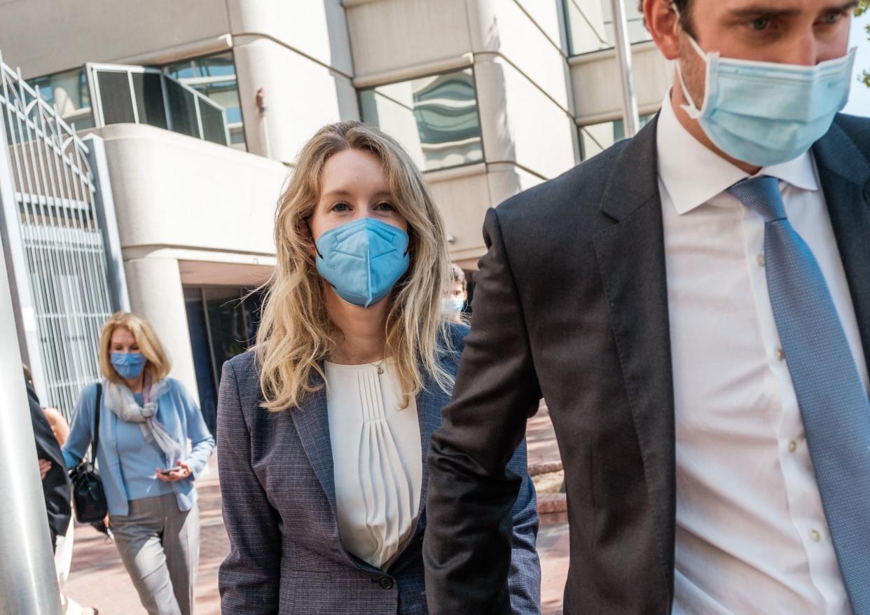 Elizabeth Holmes (L), founder and former CEO of blood testing and life sciences company Theranos, leaves the courthouse with her husband Billy Evans after the first day of her fraud trial in San Jose, California on September 8, 2021. - California jurors tasked with deciding whether fallen biotech star Elizabeth Holmes is guilty of a stunning fraud or is herself a victim were set to hear opening arguments in her trial on September 8, 2021. Federal prosecutors in the heart of Silicon Valley have in their filings portrayed Holmes as a villain who swindled investors in the diagnostics company Theranos -- which she founded at age 19 -- with tests that did not work. (Photo by Nick Otto / AFP) (Photo by NICK OTTO/AFP via Getty Images)