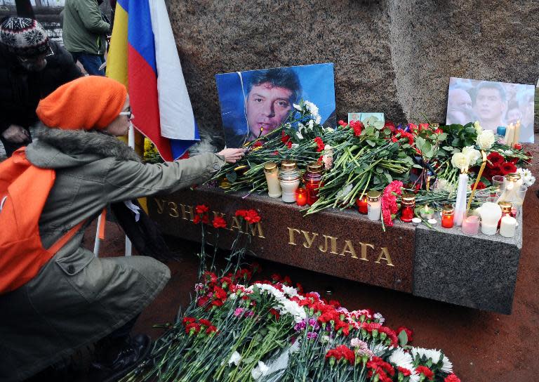 A woman places flowers on February 28, 2015 in memory of Russian opposition leader Boris Nemtsov at the Solovetsky Stone, a monument to political prisoners, in St. Petersburg