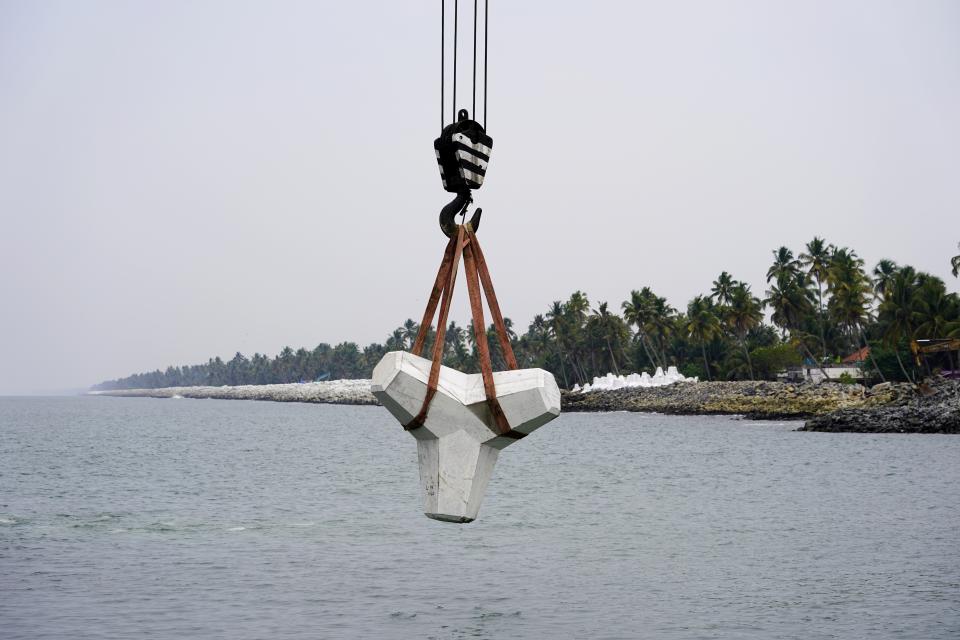 A tetrapod is lowered to the sea as part of the construction for a new sea wall in the Chellanam area of Kochi, Kerala state, India, Feb. 28, 2023. Tens of millions of people in India live along coastlines and thus are exposed to major weather events. One common adaptation technique, in India and other countries hit hard by rising seas and oceanic storms, is to build sea walls. (AP Photo)