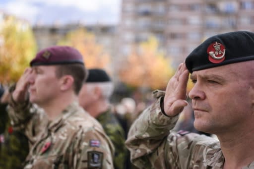 British soldiers serving in a NATO-led international peacekeeping mission in Kosovo salute as they take part in a ceremony in Pristina