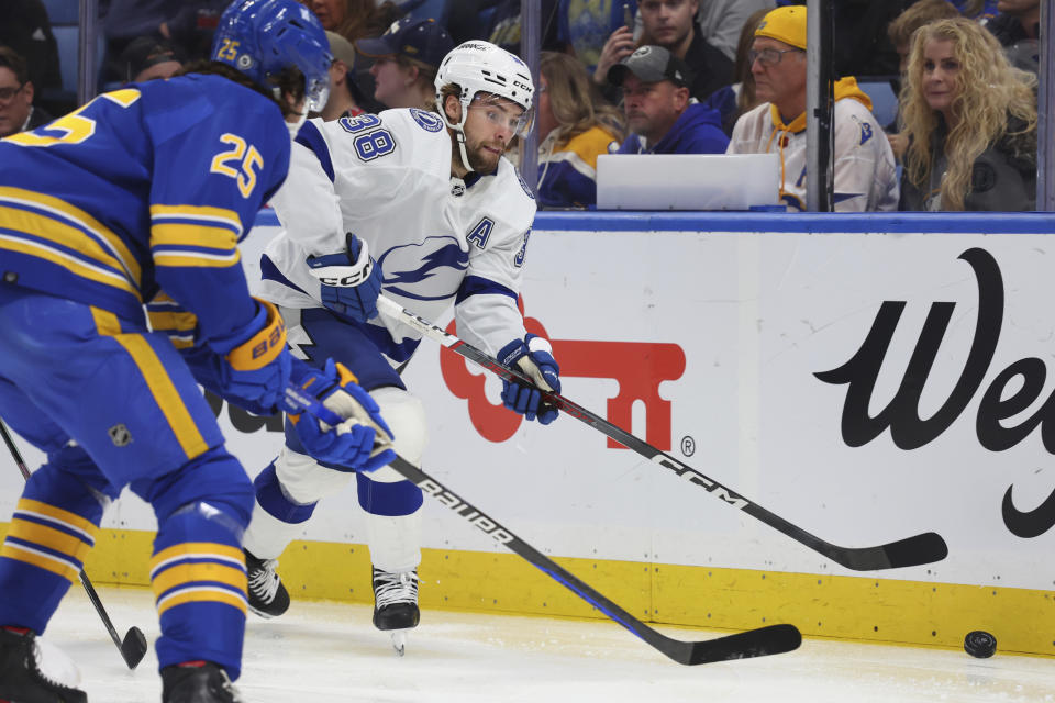 Tampa Bay Lightning left wing Brandon Hagel (38) is pressured by Buffalo Sabres defenseman Owen Power (25) during the second period of an NHL hockey game Tuesday, Oct. 17, 2023, in Buffalo, N.Y. (AP Photo/Jeffrey T. Barnes)