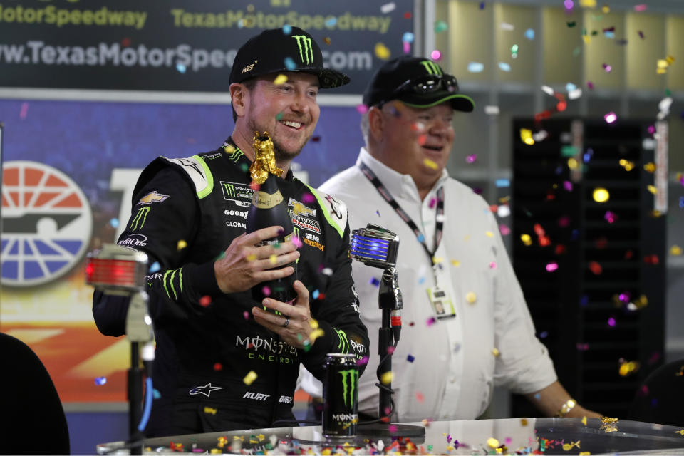 Kurt Busch, left, and team owner Chip Ganassi, right, celebrate after announcing a multi-year contract for Busch with Ganassi racing during a NASCAR news conference at Texas Motor Speedway in Fort Worth, Texas, Saturday, Nov. 2, 2019. (AP Photo/Roger Steinman)