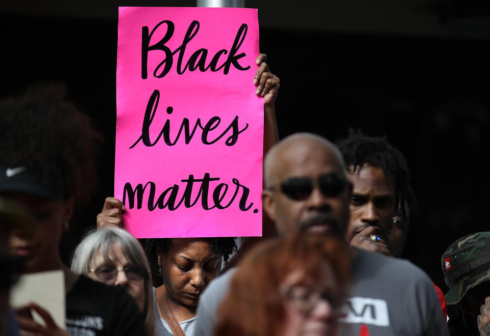 A woman holds a bright "Black Lives Matter" sign during the demonstration.