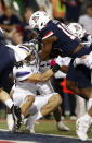 Arizona wide receiver Jamarye Joiner (10) scores a 1-yard touchdown over Washington linebacker Jackson Sirmon (43) during the first half of an NCAA college football game Friday, Oct. 22, 2021, in Tucson, Ariz. (AP Photo/Chris Coduto)