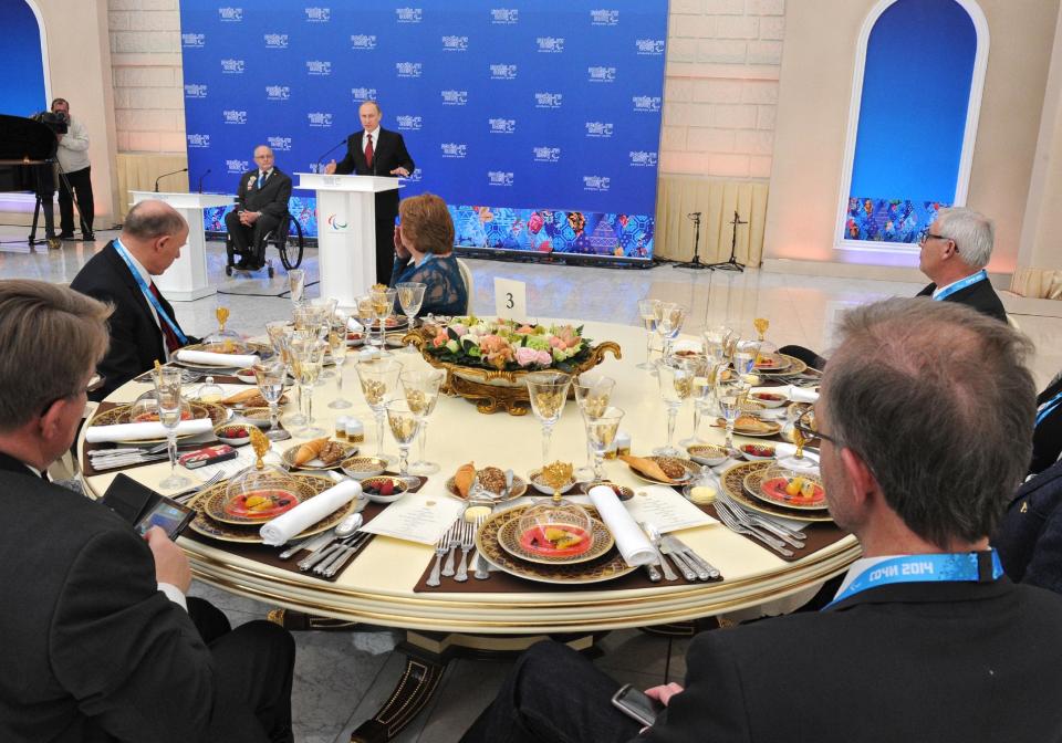 Russian President Vladimir Putin, background center, speaks during a meeting with heads of national paralympic committees as President of the International Paralympic Committee Philip Craven, background, second left, listens in Sochi, Russia, Thursday, March 13, 2014. (AP Photo/RIA Novosti Kremlin, Mikhail Klimentyev, Presidential Press Service)