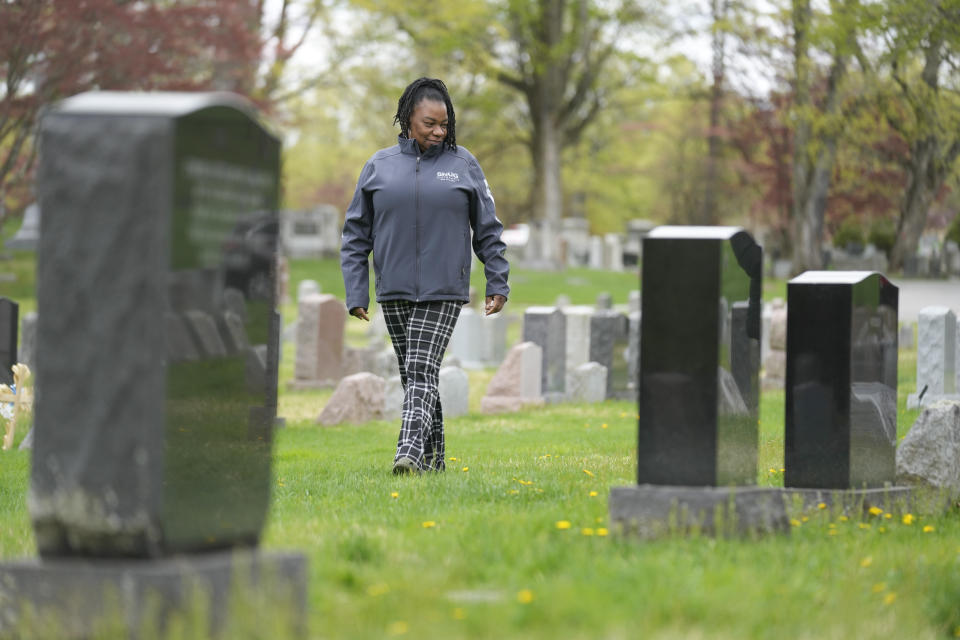 Debra Long camina junto a la tumba de su hijo, Randy Long, en Poughkeepsie, Nueva York, el 19 de abril de 2023. Un análisis de datos de AP de 23 estados muestra que a las personas negras se les rechaza de forma desproporcionada la compensación estatal para víctimas de crímenes violentos. (AP Foto/Seth Wenig)