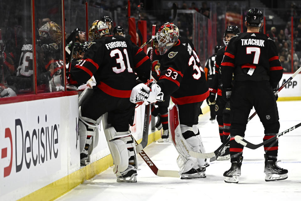 Ottawa Senators goaltender Cam Talbot (33) taps goaltender Anton Forsberg (31) as he leaves the ice after letting in three goals in the first period of NHL hockey game action against the Seattle Kraken in Ottawa, Ontario, Saturday, Jan. 7, 2023. (Justin Tang/The Canadian Press via AP)