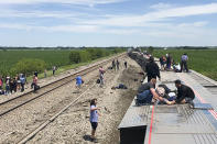 In this photo provided by Dax McDonald, an Amtrak passenger train lies on its side after derailing near Mendon, Mo., on Monday, June 27, 2022. The Southwest Chief, traveling from Los Angeles to Chicago, was carrying about 243 passengers when it collided with a dump truck near Mendon, Amtrak spokeswoman Kimberly Woods said. (Dax McDonald via AP)