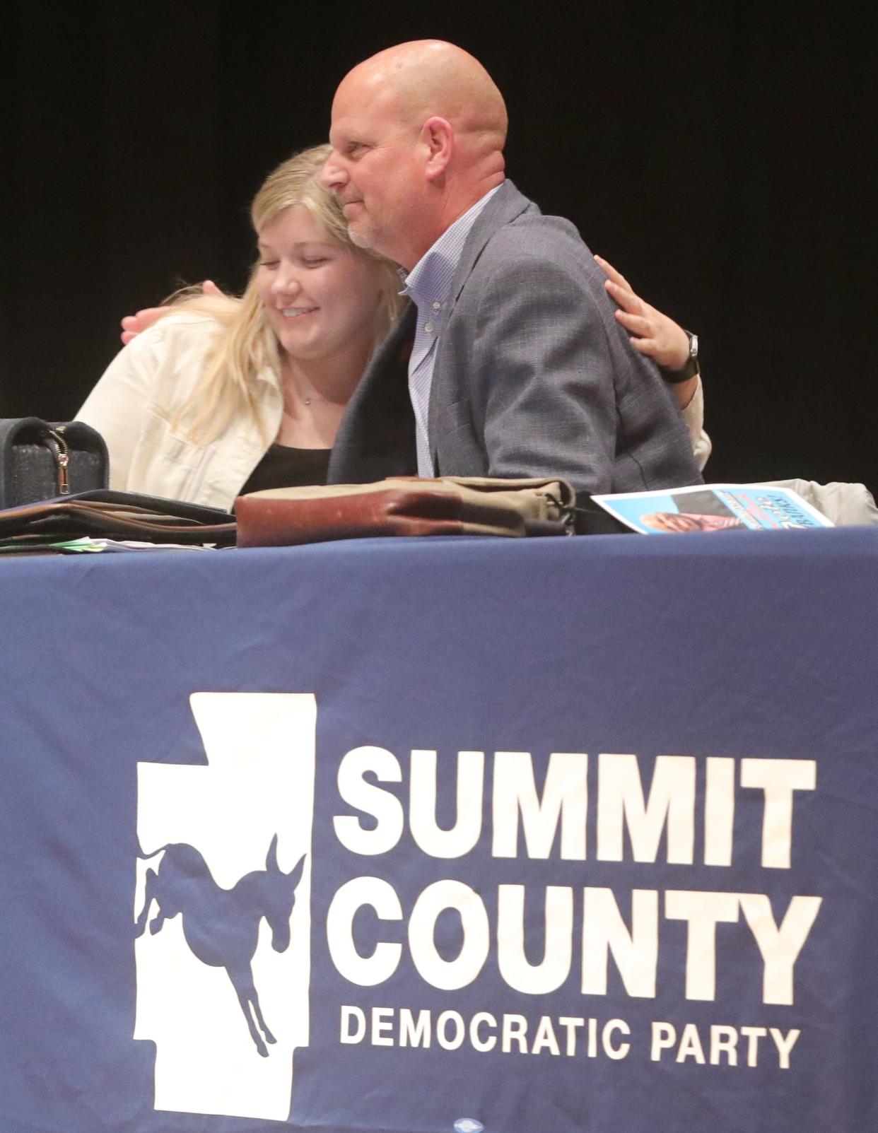 Newly elected Summit County Democratic Party Chair Mark Derrig is congratulated by Treasurer Morgan Ferrell during an organizational meeting Wednesday at North High School in Akron.