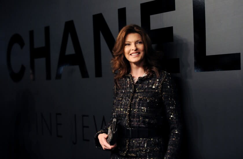 A woman posing in front of a large Chanel sign