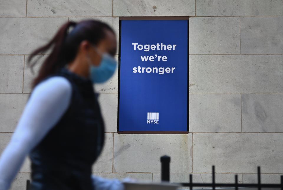 People walk by the New York Stock Exchange (NYSE) in lower Manhattan on October 5, 2020 in New York City. (Photo by ANGELA WEISS/AFP via Getty Images)