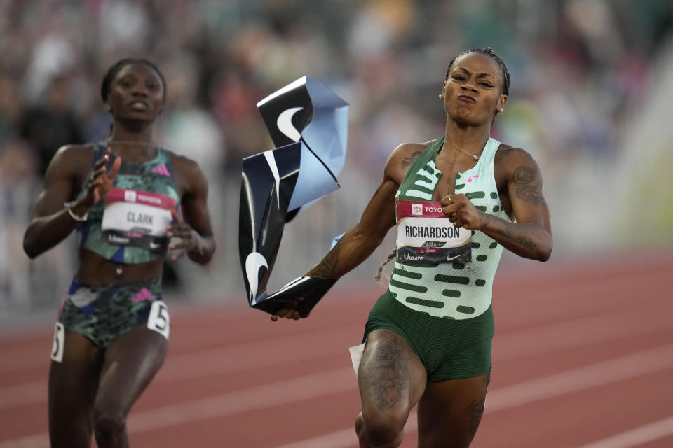 FIILE - Sha'Carri Richardson grabs the tape as she wins the women's 100 meter finals ahead of Tamara Clark during the U.S. track and field championships in Eugene, Ore., Friday, July 7, 2023. (AP Photo/Ashley Landis, File)