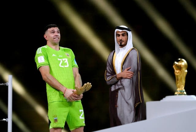 Emiliano Martinez celebrates with a lewd gesture with his World Cup Golden Glove award