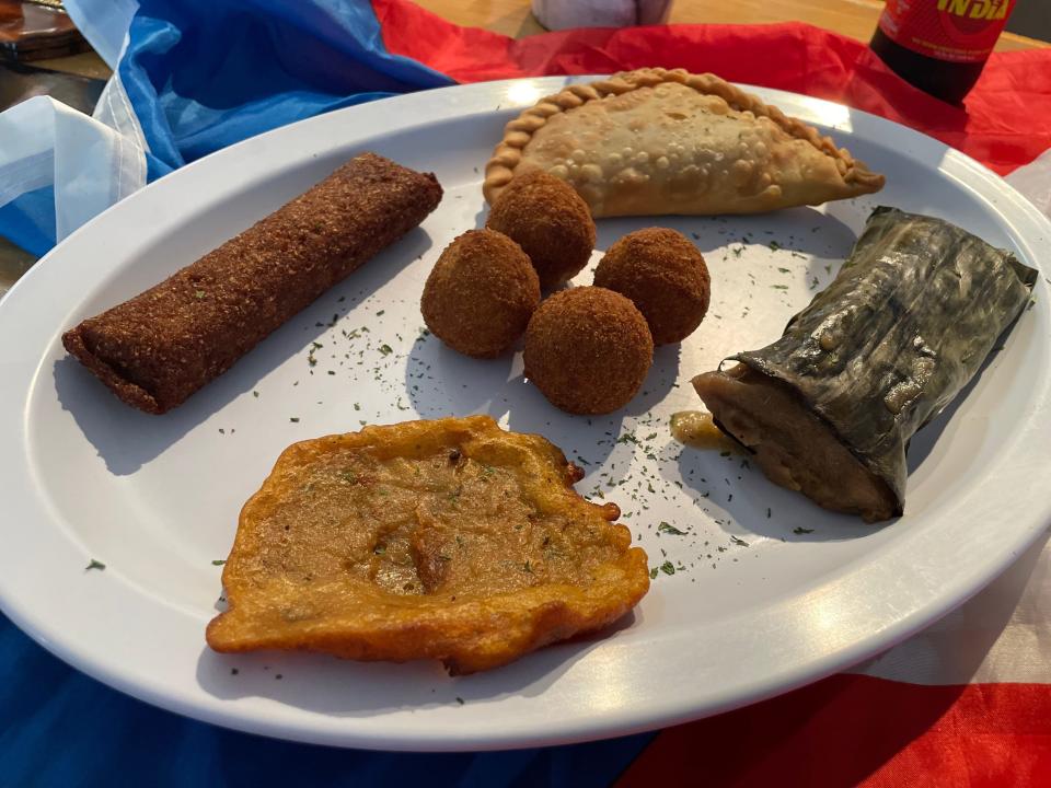 El Viejo San Juan platter, served at Isla del Coqui, features a stuffed potatoes, a beef empanada, bacalaito - cod fish fritters- alcapurria -fritter made of green plantains and taro - and a pastel, which is similar to a tamale.