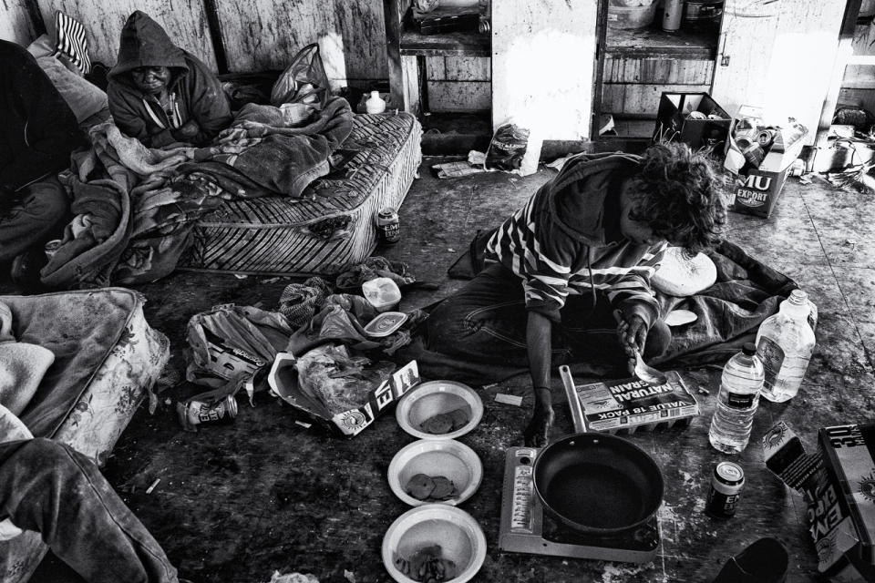This week is a good week there is extra money to pool. First meal of the day for this family consists of bacon, eggs and damper cooked inside a condemned building in the One Mile Community, just on the entrance to the tourism town of Broome. Western Australia. (Photograph by Ingetje Tadros)