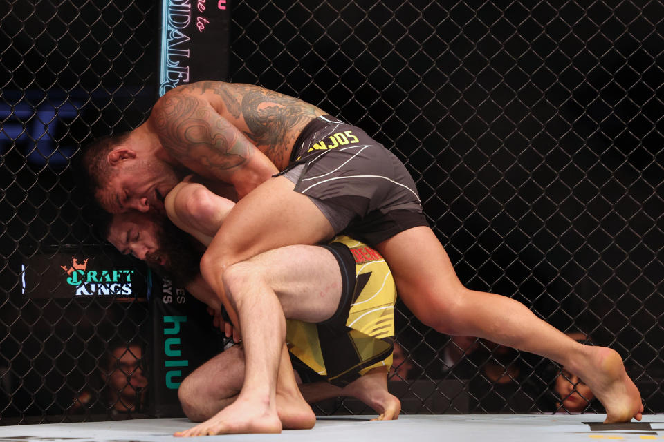 Dec 3, 2022; Orlando, Florida, USA; Bryan Barberena (red gloves) fights Rafael Dos Anjos (blue gloves) during UFC Fight Night at Amway Center. Mandatory Credit: Nathan Ray Seebeck-USA TODAY Sports