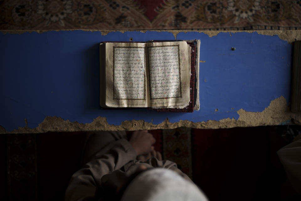 FILE - A student reads the Quran, Islam's holy book, at a madrasa in Kabul, Afghanistan, Tuesday, Sept. 28, 2021. The American concept of adoption doesn’t exist in Afghanistan. Under Islamic law, a child’s bloodline cannot be severed and their heritage is sacred. Instead of adoption, a guardianship system called kafala allows Muslims to take in orphans and raise them as family, without relinquishing the child’s name or bloodline. (AP Photo/Felipe Dana, File)