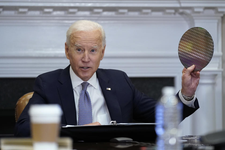 President Joe Biden holds up a silicon wafer as he participates virtually in the CEO Summit on Semiconductor and Supply Chain Resilience in the Roosevelt Room of the White House, Monday, April 12, 2021, in Washington. (AP Photo/Patrick Semansky)