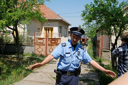 FILE PHOTO: A policeman blocks the entrance of the house where Bosnian Serb wartime general Ratko Mladic was arrested in the village of Lazarevo, Serbia, May 27, 2011. REUTERS/Ivan MIlutinovic/File Photo