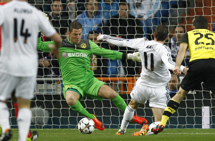 Real's Gareth Bale, second right, scores the opening goal past Dortmund goalkeeper Roman Weidenfeller during a Champions League quarterfinal first leg soccer match between Real Madrid and Borussia Dortmund at the Santiago Bernabeu stadium in Madrid, Spain, Wednesday, April 2, 2014. (AP Photo/Andres Kudacki)