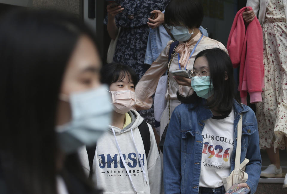 People wear face masks to help protect against the spread of the coronavirus as they cross an intersection in Taipei, Taiwan, Thursday, April 29, 2021. (AP Photo/Chiang Ying-ying)